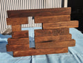 Wooden sculpture with 'BELIEVE' engraved on it, placed on a blue surface.