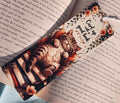 Decorative bookmark with cats and floral design on a book page