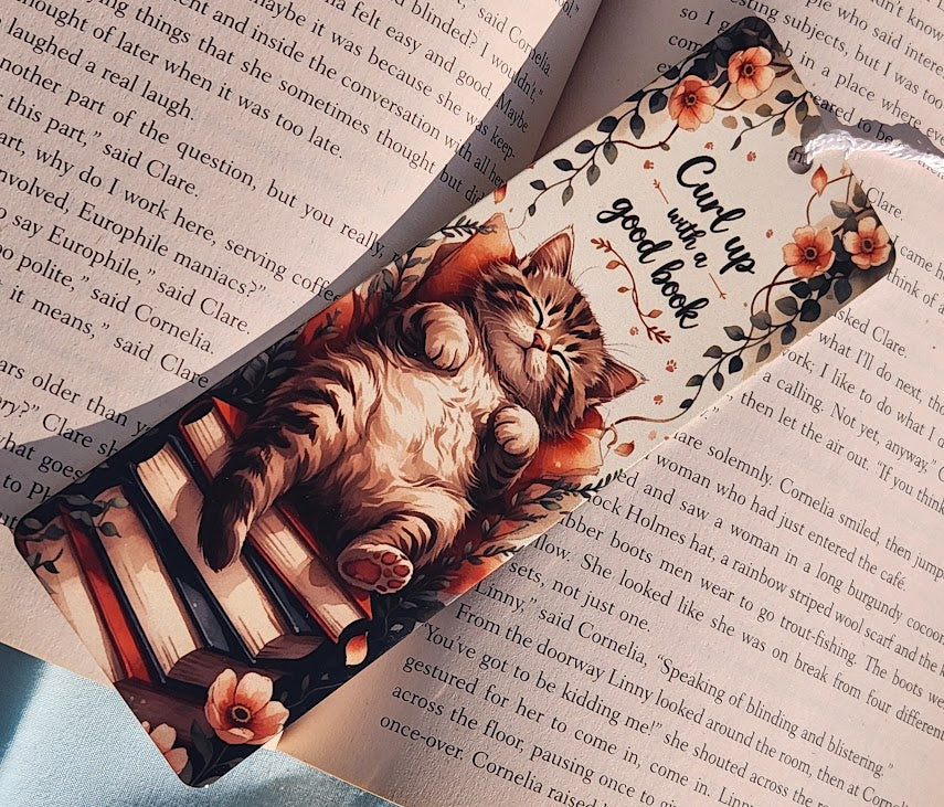Decorative bookmark with cats and floral design on a book page