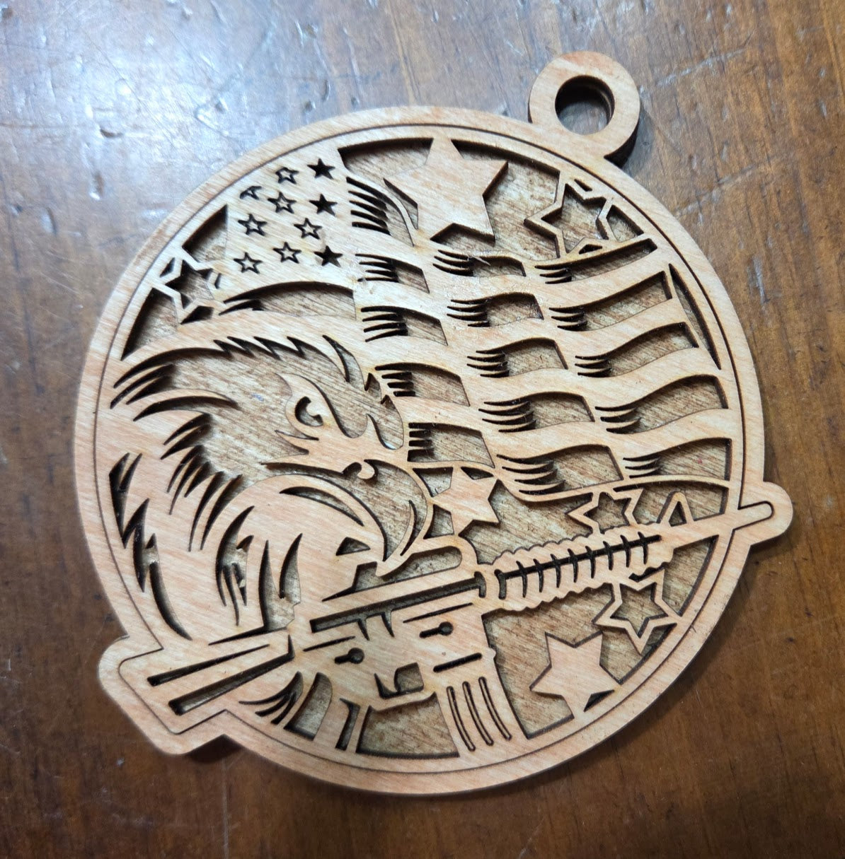 Wooden ornament with eagle and American flag design on a wooden surface