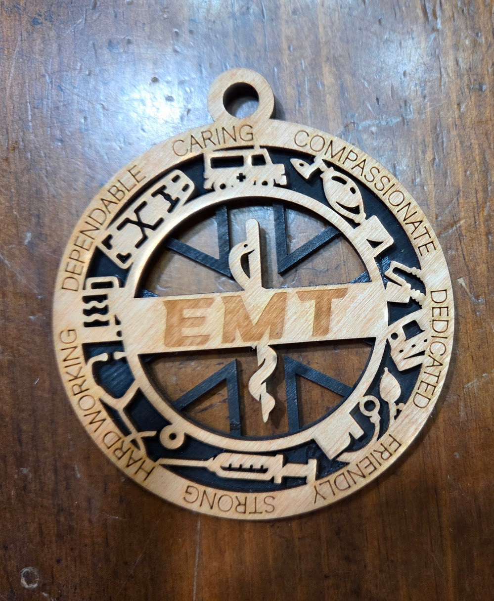 Wooden EMT pendant with engraved text on a wooden surface