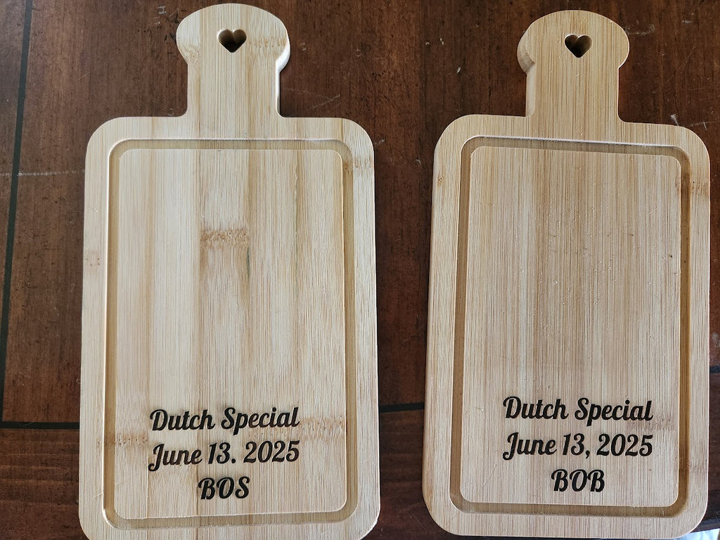 Two wooden cutting boards with engraved text on a wooden surface