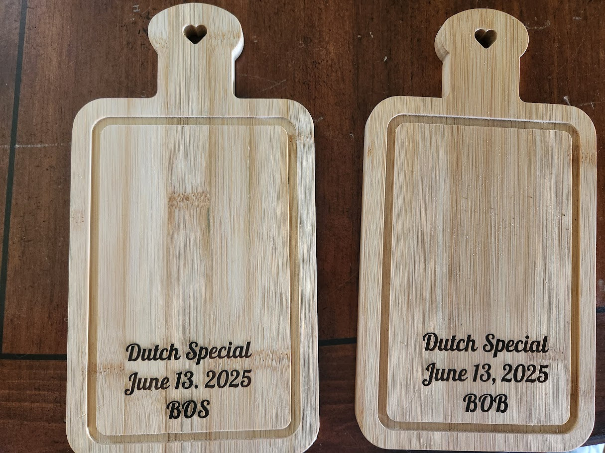 Two wooden cutting boards with engraved text on a wooden surface