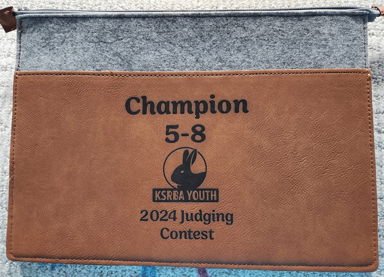 Brown leather pouch with 'Champion 5-8' and 'KSKRA Youth 2024 Judging Contest' text on a gray background
