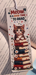 Bookmark with a cat illustration and text 'Meow is a good time to read' on a book page background.