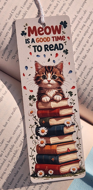 Bookmark with a cat illustration and text 'Meow is a good time to read' on a book page background.