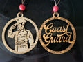 Two wooden coast guard-themed ornaments with engraved text on a dark background.