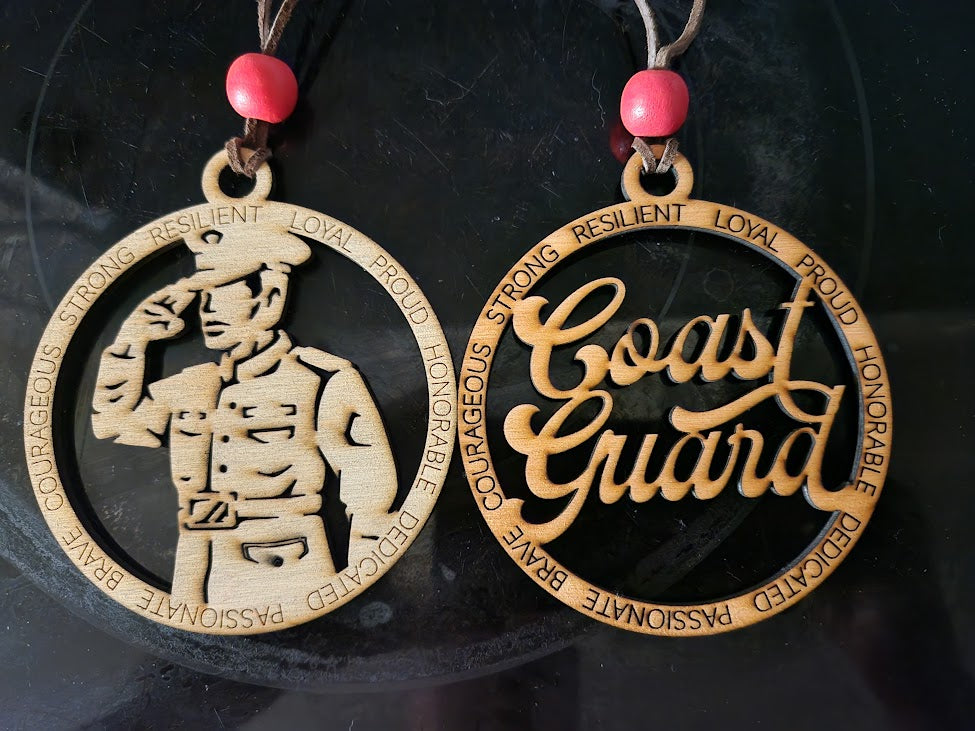 Two wooden coast guard-themed ornaments with engraved text on a dark background.