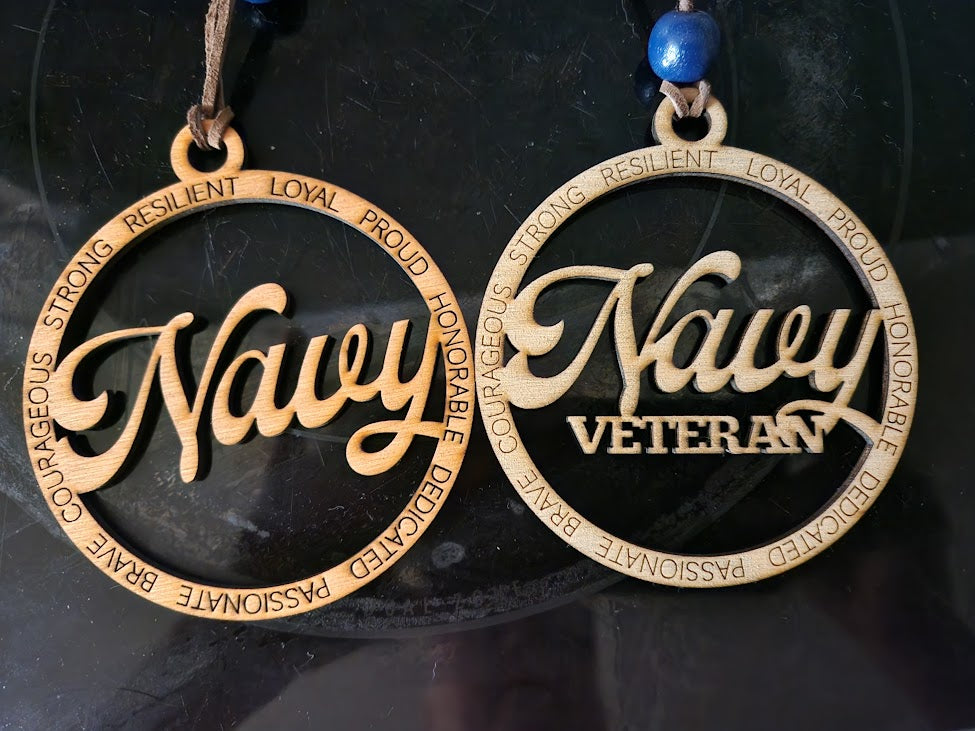 Two round 'Navy' and 'Navy Veteran' pendants on a dark background.