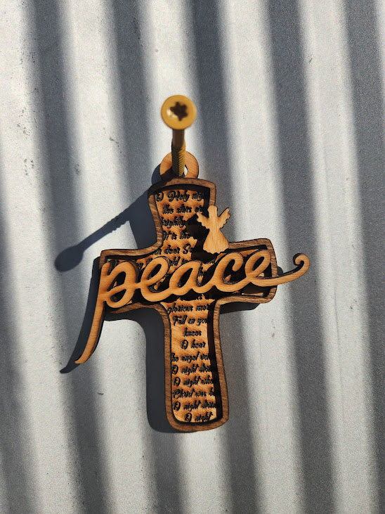 Decorative cross with 'peace' text on a corrugated metal background