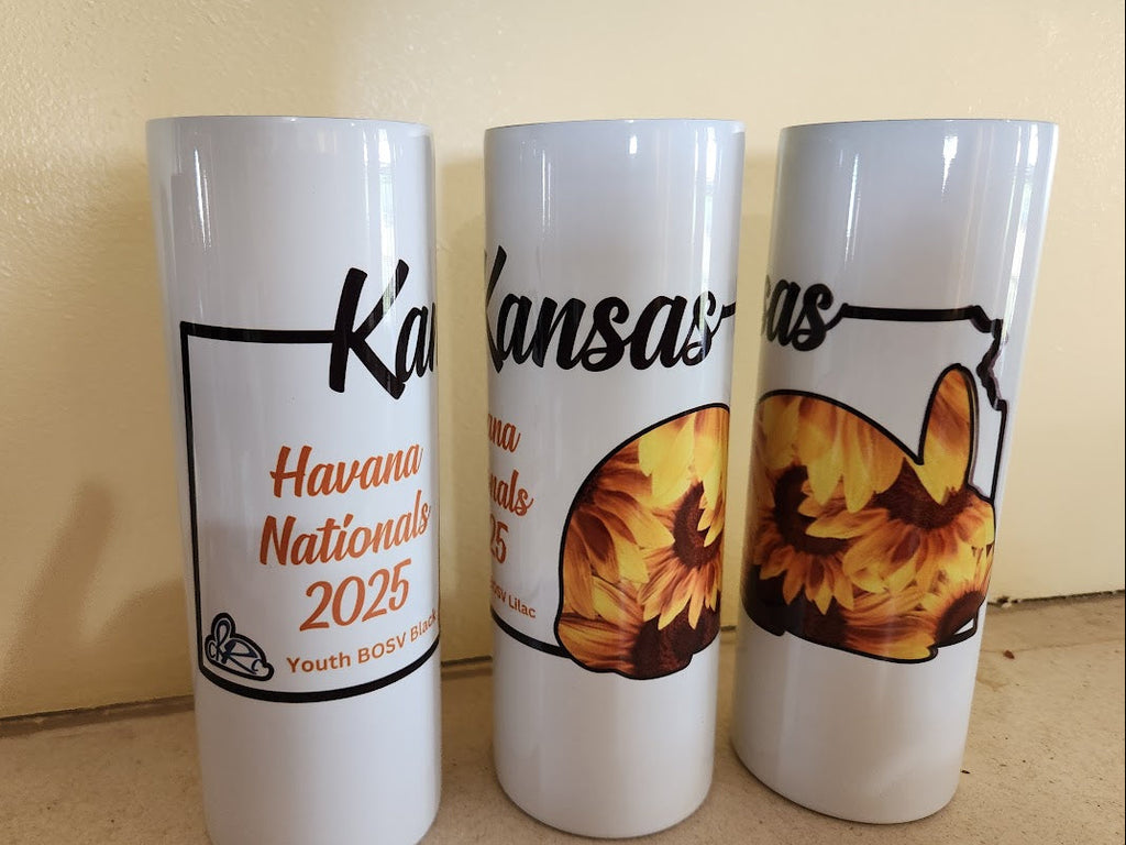 Three white tumblers with printed designs on a beige background