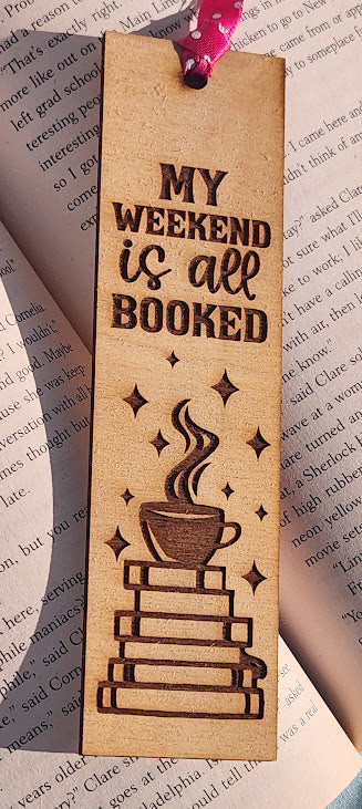 Bookmark with 'My weekend is all booked' text and coffee cup design on a book page background